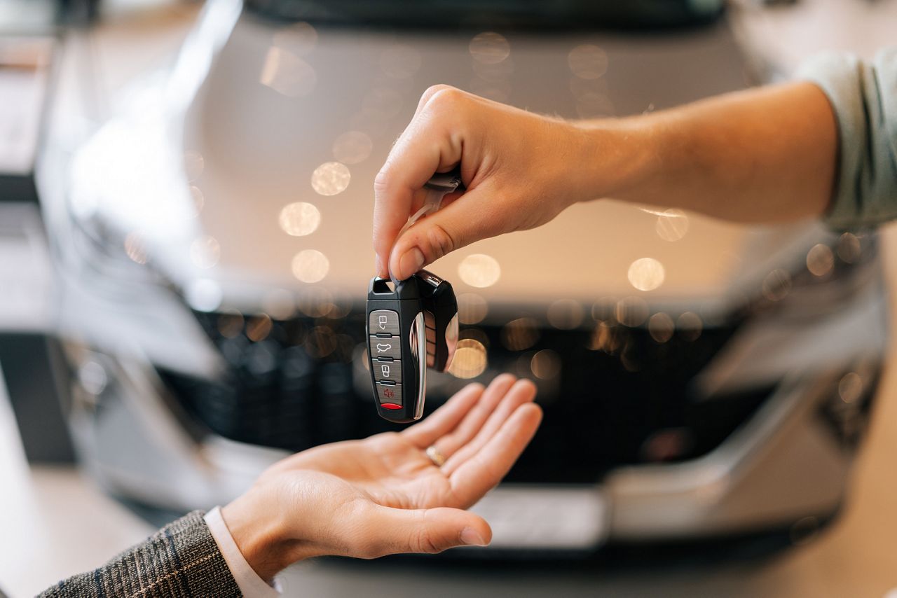 Closeup image of a vehicle key with a blurred image of a car in the background