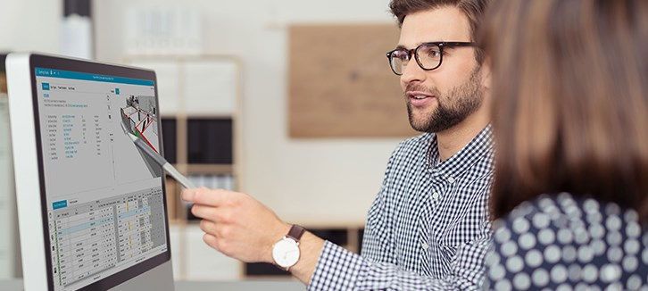 man talking to a woman at a computer