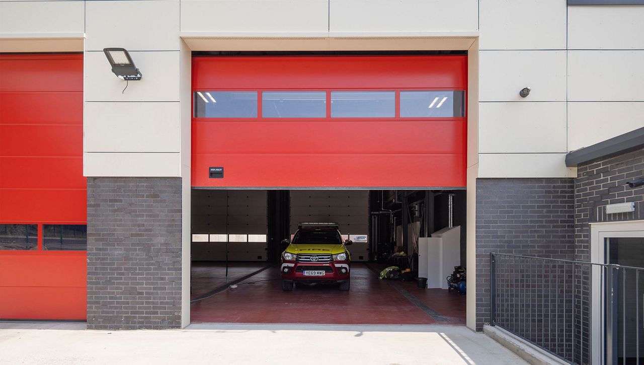 Image: An external image of a Crawford OH1042S overhead sectional doors open with a fire truck 