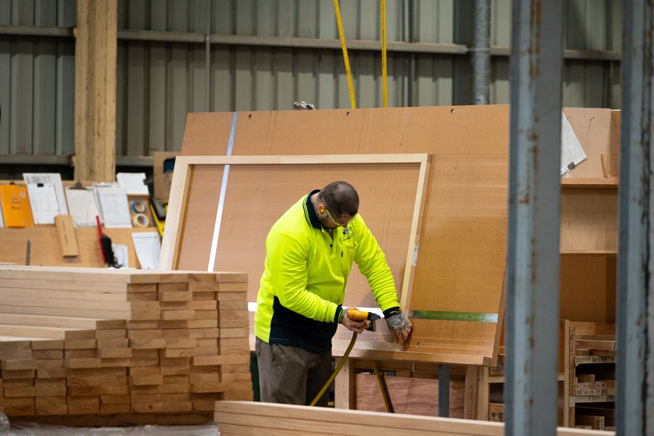A Spence Doors production worker building a door at a workstation