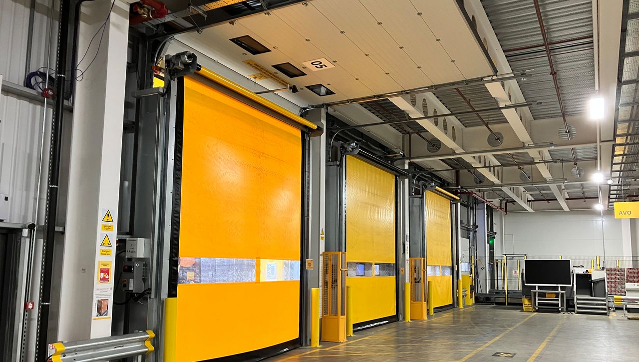 A row of ASSA ABLOY day and night doors, with a overhead sectional doro and high speed door