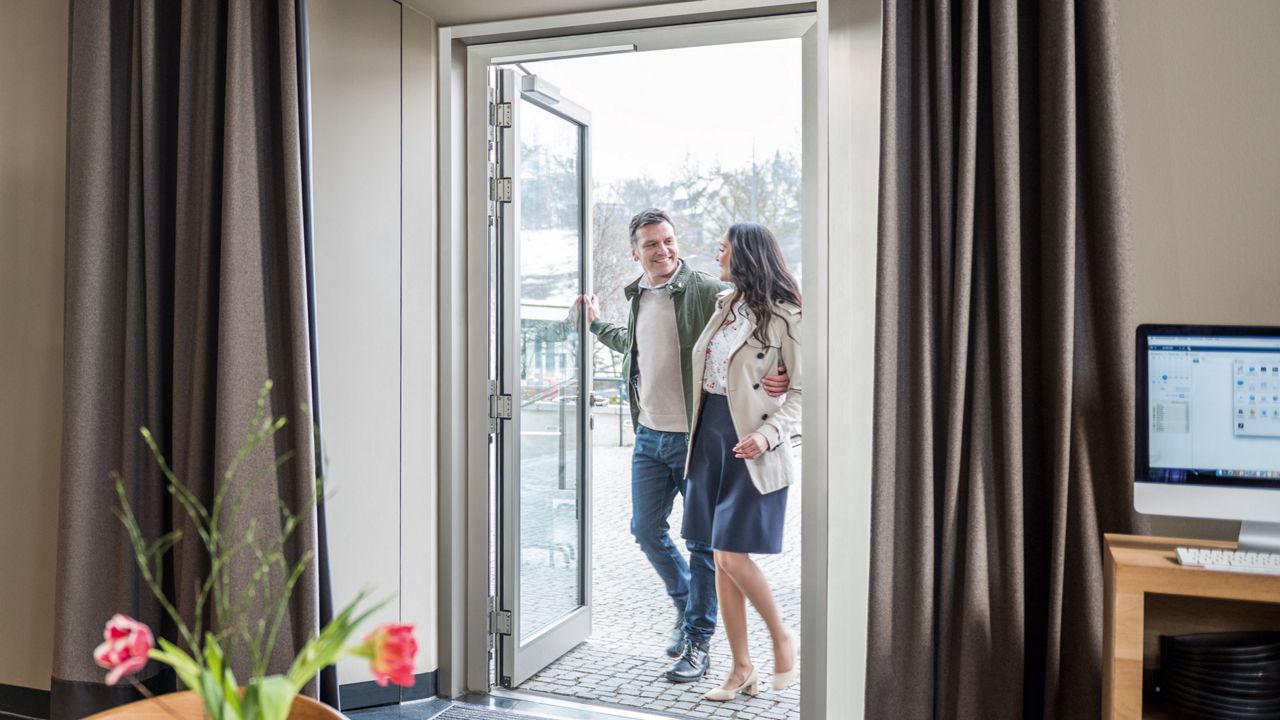 Coppia apre una porta con chiudiporta