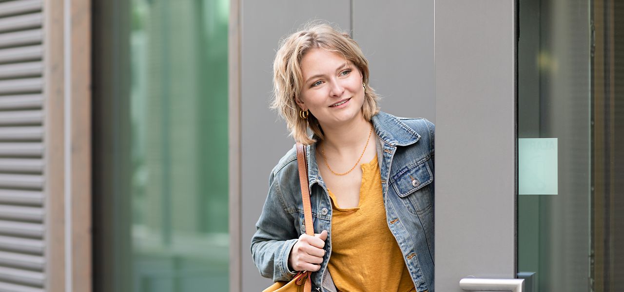 Vrouw loopt door deur met ASSA ABLOY deurdranger