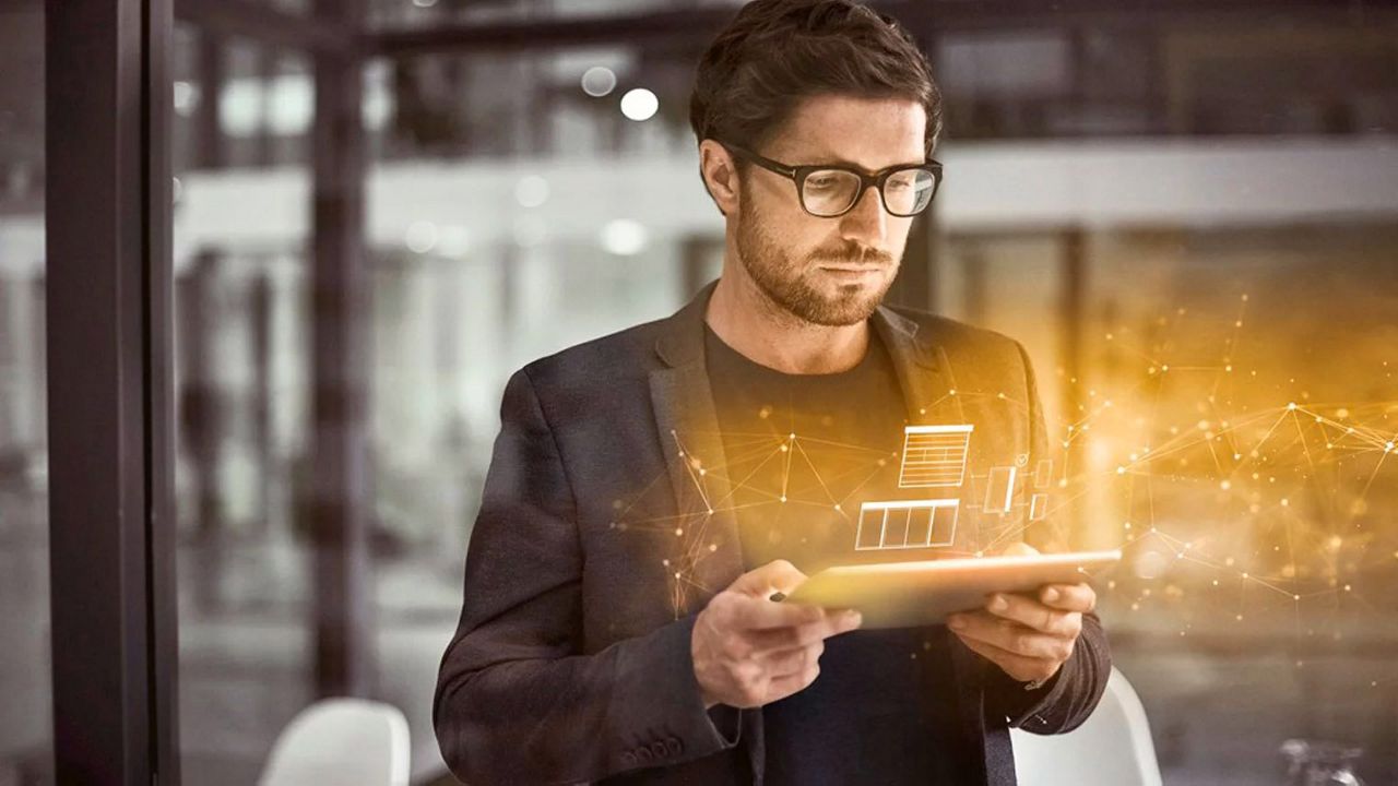 Uomo controlla il tablet con una rappresentazione olografica