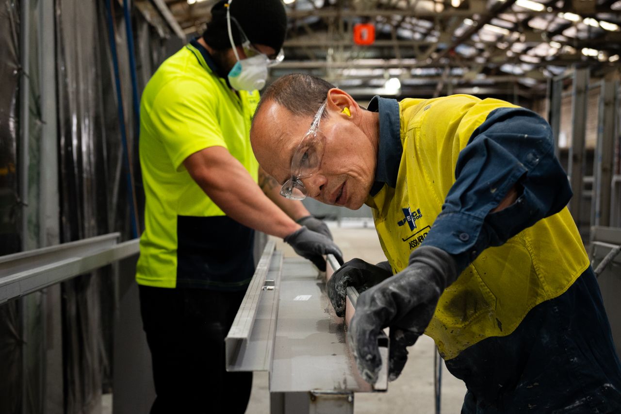 Workers backfilling a pressed metal door frame