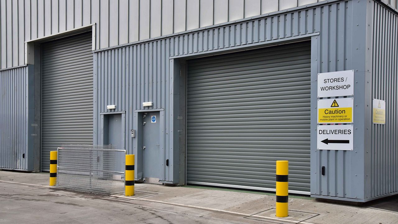 Two black insulated roller shutter doors next to each other on a big building. 