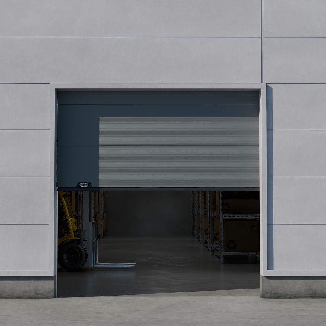 Ușă secțională industrială culisantă pe verticală, parțial deschisă, cu un stivuitor care intră într‑un depozit printr‑o deschidere înaltă într‑o fațadă de beton.