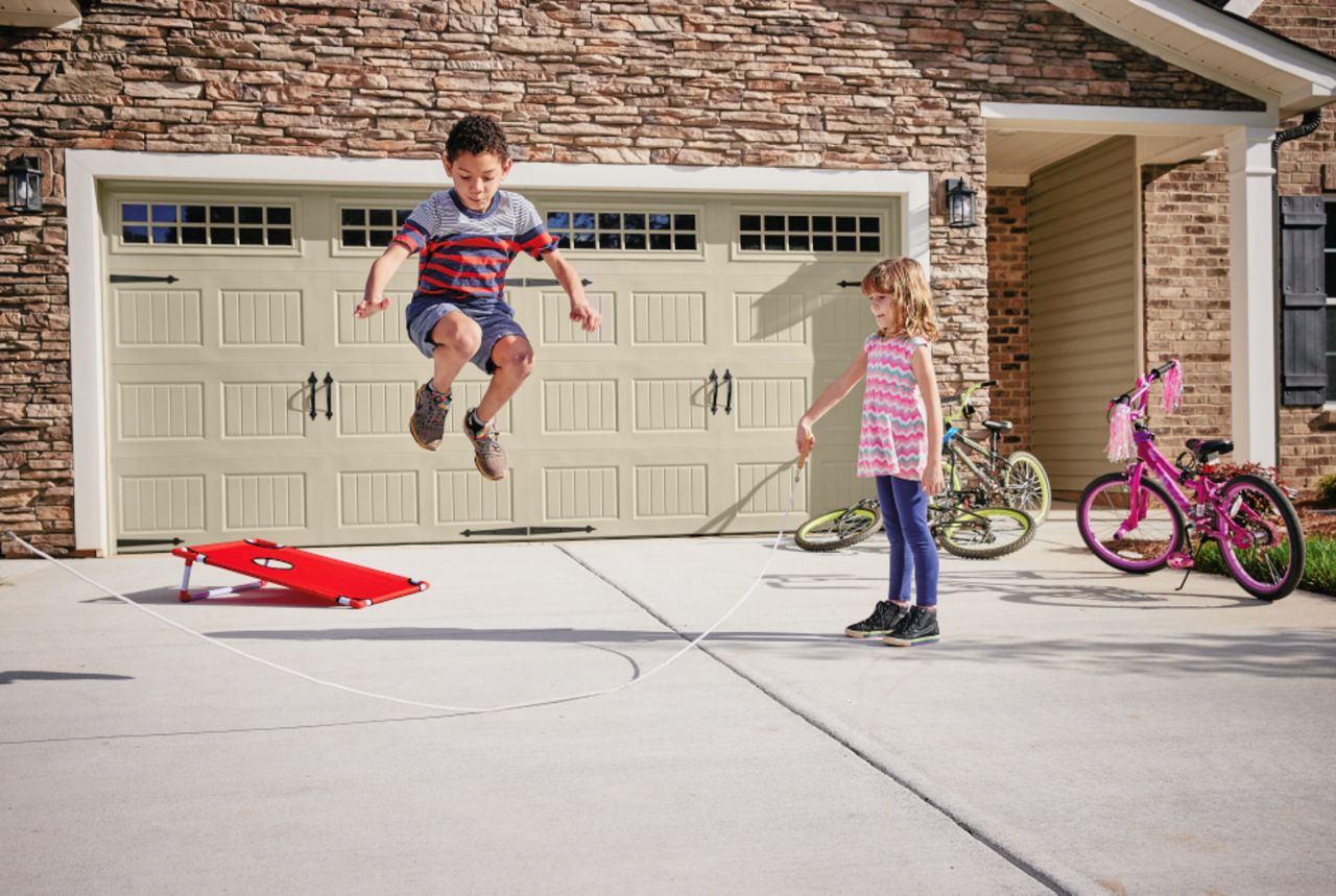 Enfant jouant devant une maison sécurisée par un bloc porte blindée vachette certifié BP1