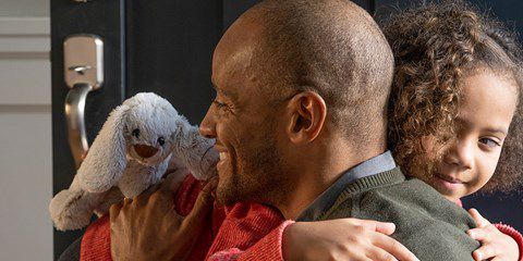 Un bărbat îmbrățișând un copil