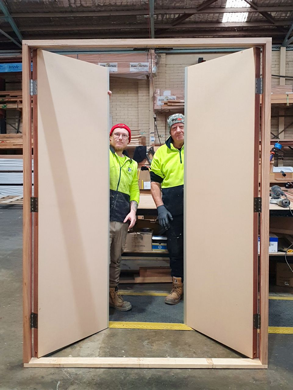 Two Spence Doors production team members with a pre-hung timber door