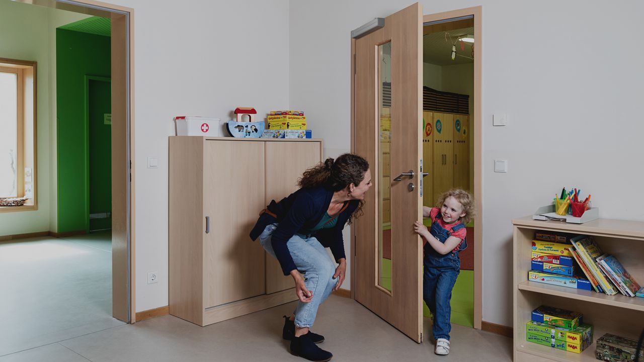 Un enfant passe par une porte avec un ferme-porte Close-Motion