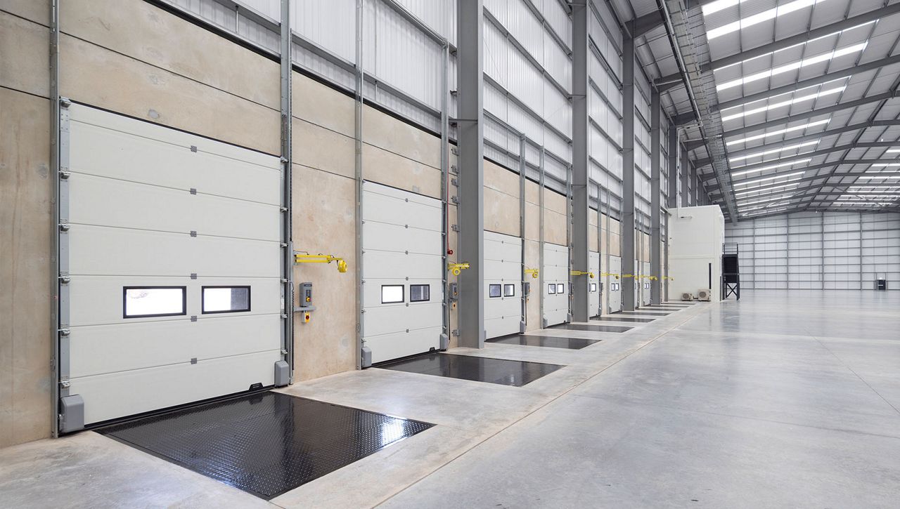 Image: The Crawford OH1142P dual drive sectional door installed in a loading bay of a UK warehouse