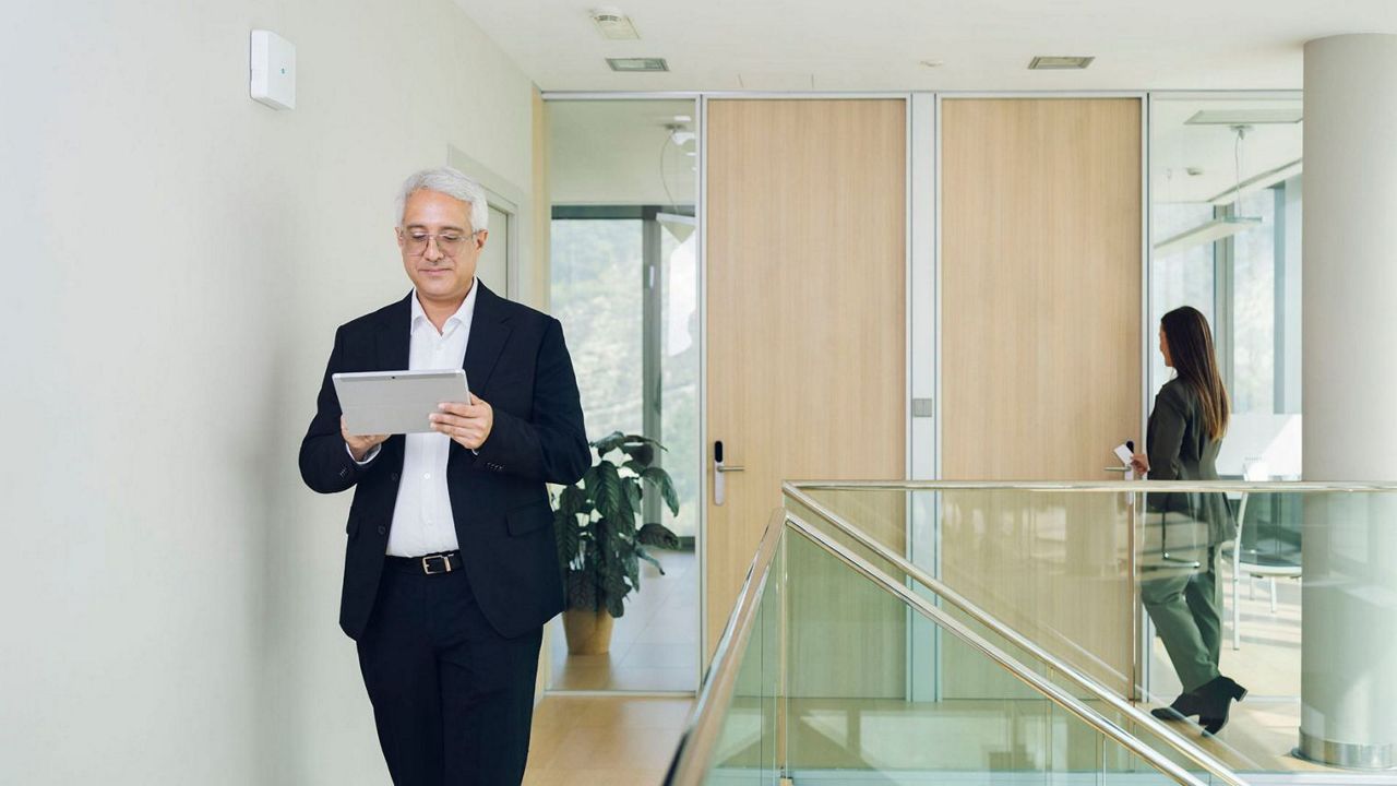 Un homme qui consulte une tablette dans un couloir