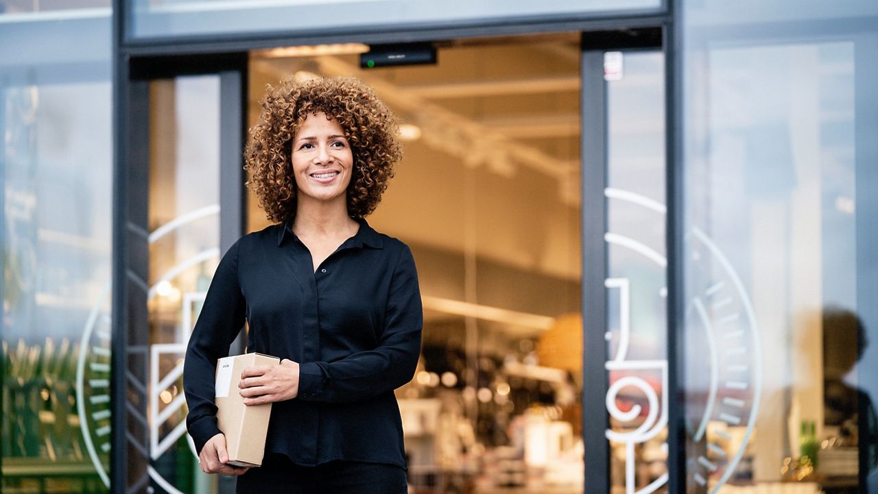 woman exiting ASSA ABLOY glass double entry door system