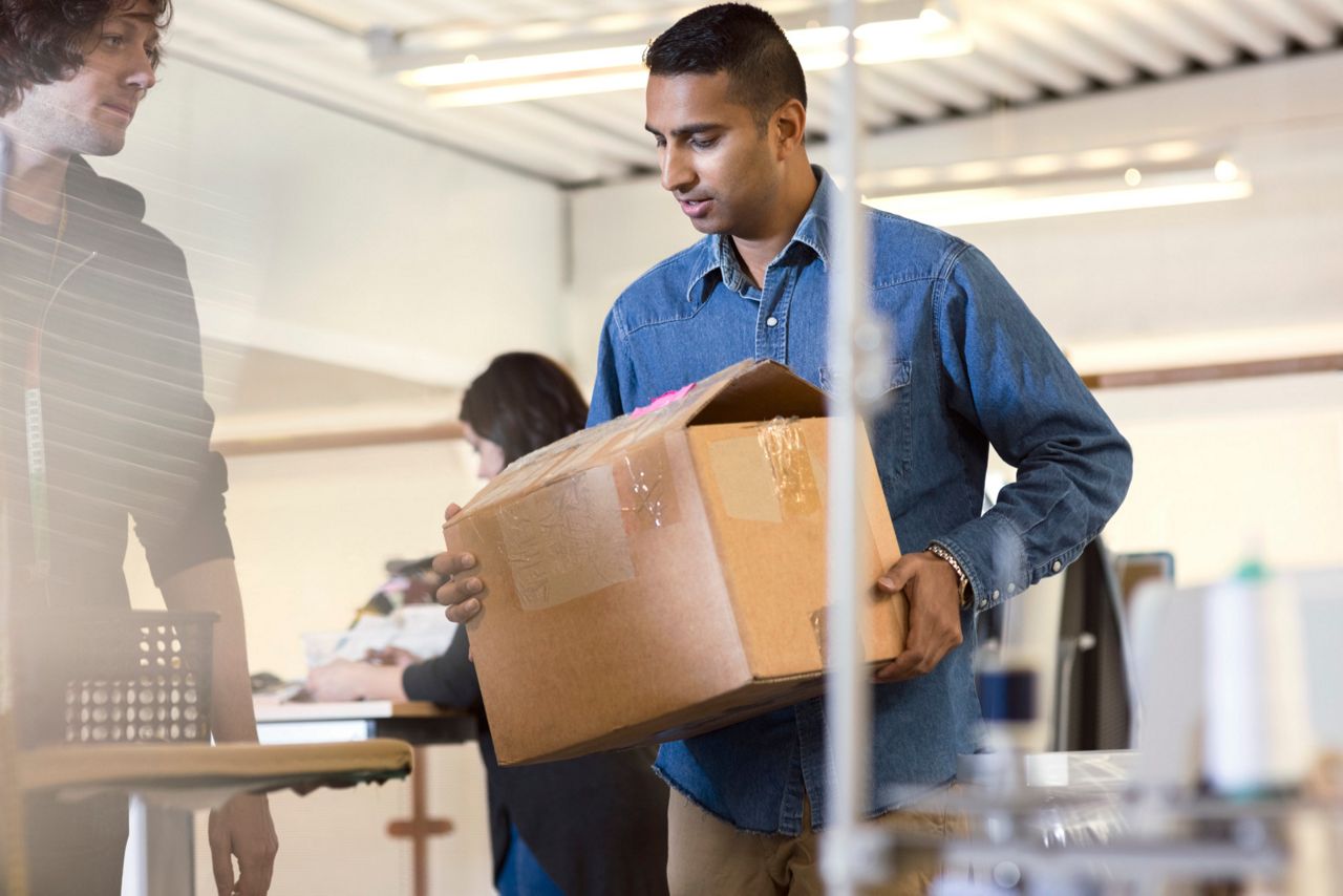 Homme qui transporte un carton pour emménager dans son logement sécurisé par Point Fort Fichet