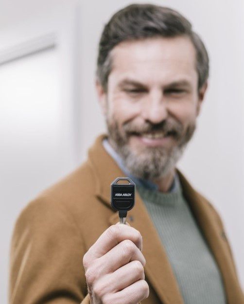 Homme présentant une clé à reproduire à un serrurier expert.