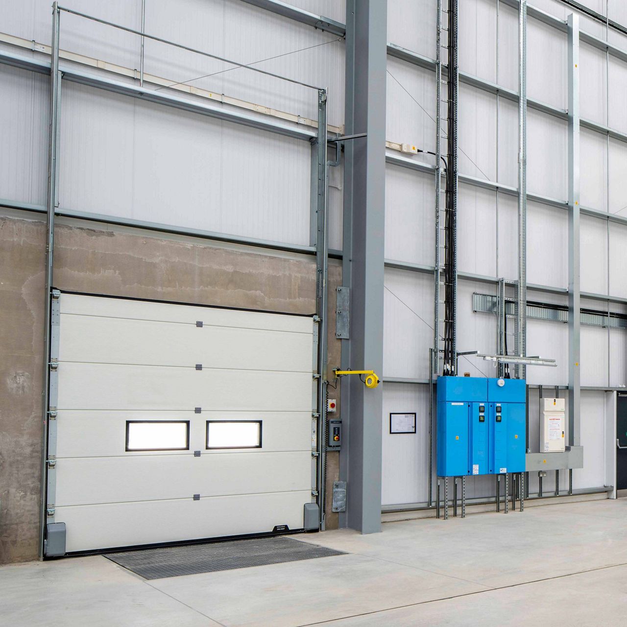 ASSA ABLOY OH1142P dual drive sectional door in a warehouse environment
