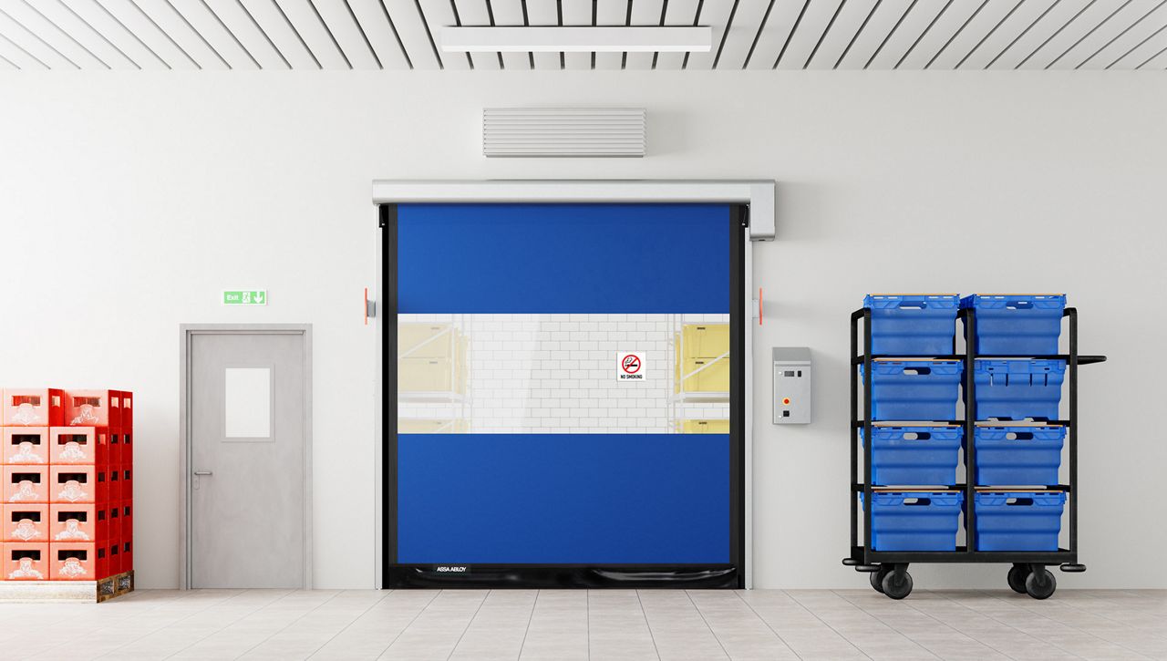 A blue food processing high speed door in a grey room with food.