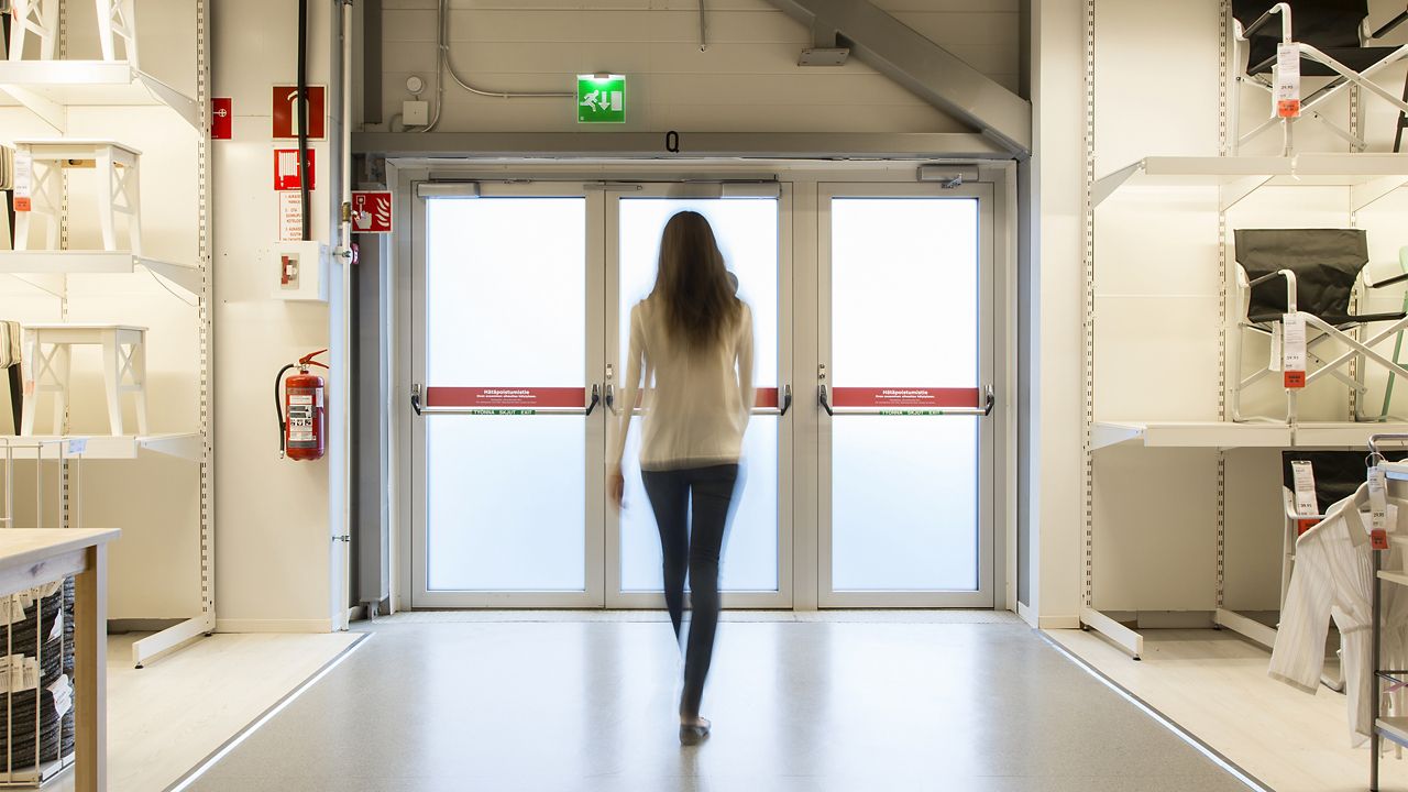 Nainen kävelemässä kohti ulko-ovea
