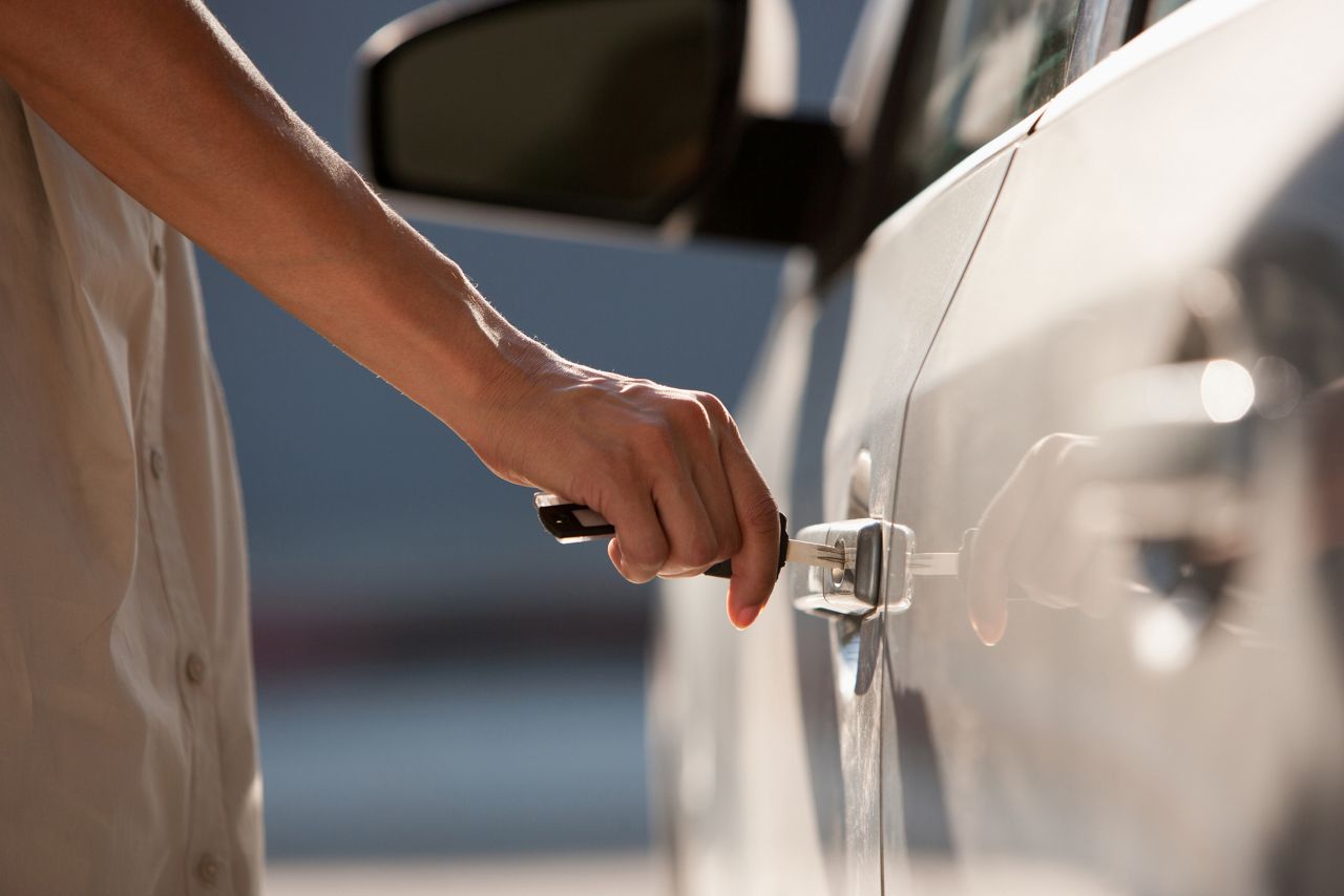 Man putting key in car door