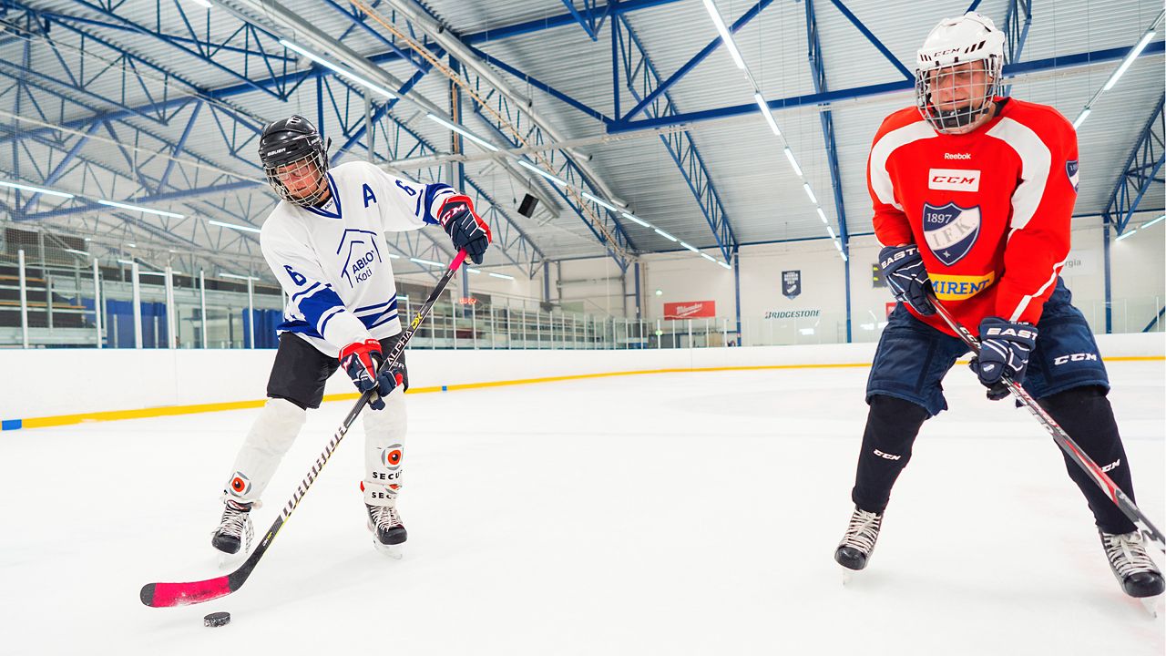Tapani and Joona playing ice hockey.