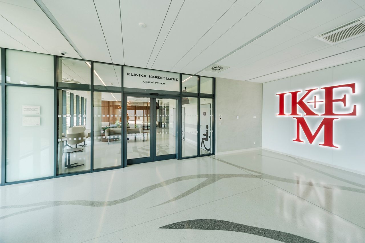 Vstupní vestibul do nové budovy G1 a G2 Institutu klinické a experimentální medicíny v Praze (IKEM). Nparavo je velký červený nápis IKEM a ve středu jsou automatické pousvné dveře ASSA ABLOY Entrance Systems.