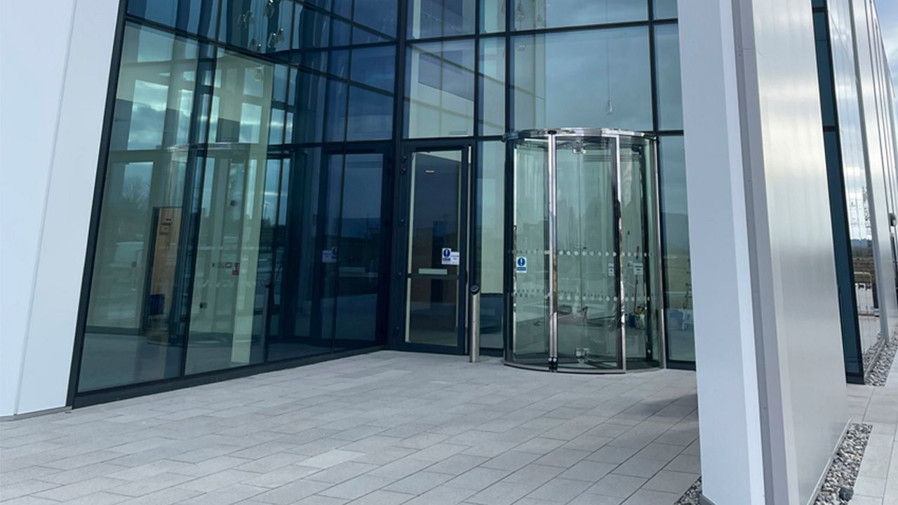 Illustration d’une entrée d’immeuble de bureaux avec la porte tournante ASSA ABLOY RD300.