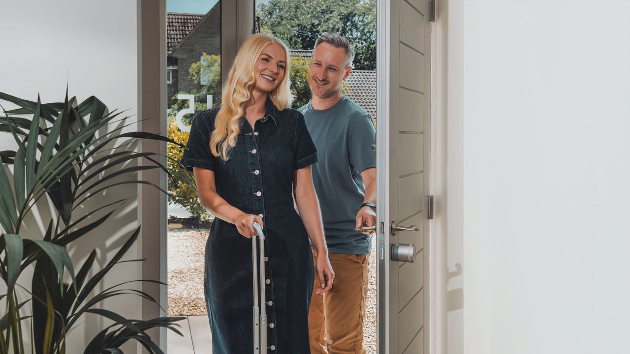 Un homme et une femme entrent dans la maison sans clés, grâce à la serrure intelligente Linus® L2 Lite.
