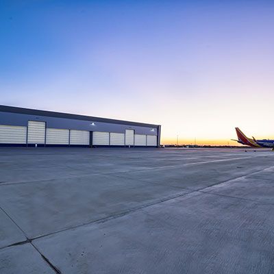 Foto vom Sonnenuntergang eines großen Flugzeughangars mit Megadoors.