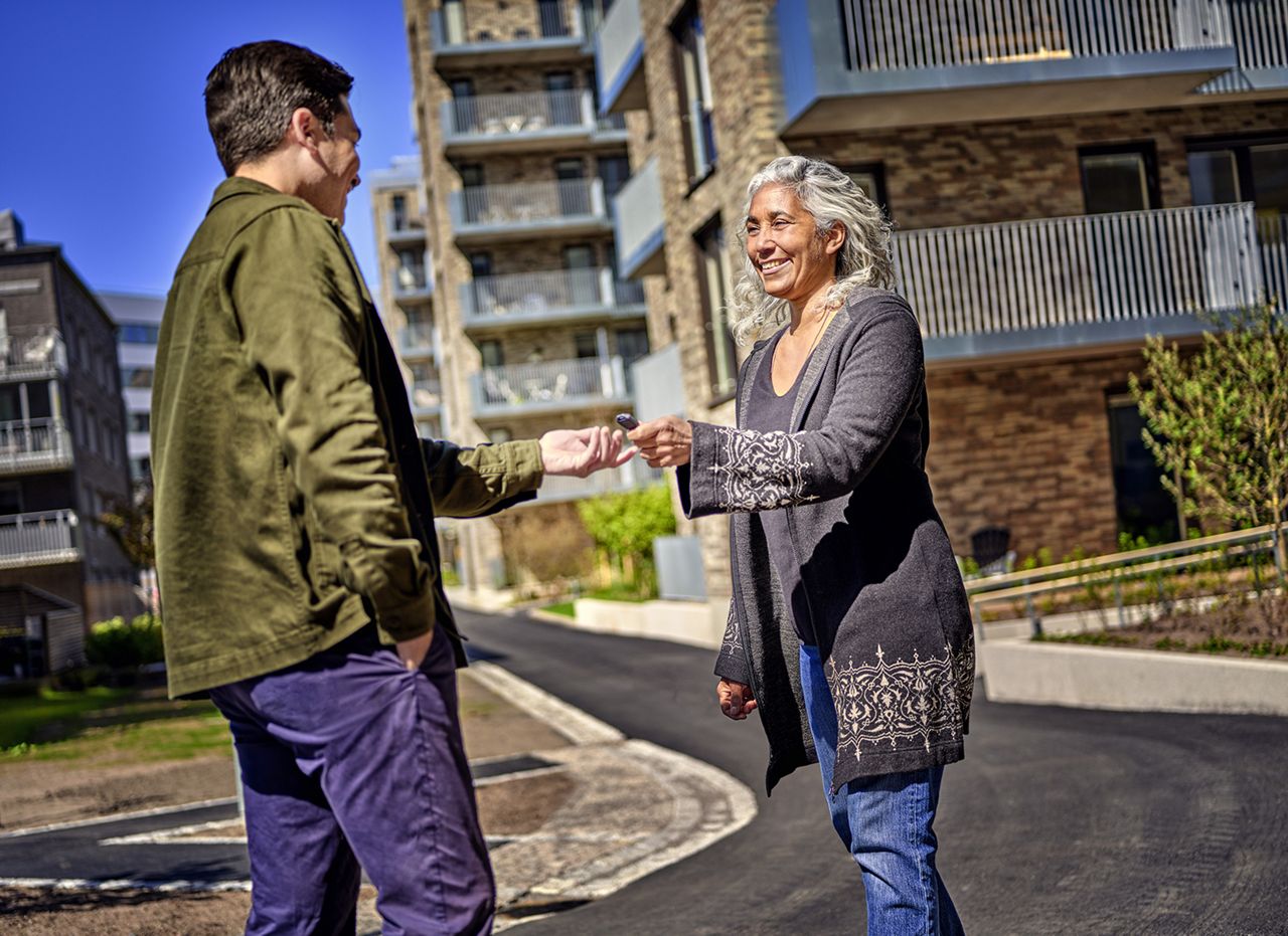 Man gives older woman an ASSA ABLOY Pulse key.