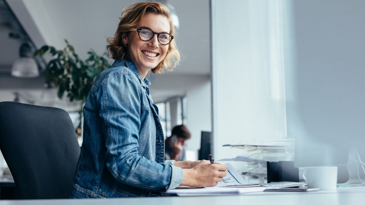 Kvinne sitter ved et skrivebord.