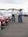 Salesman showing customers new vehicles on franchise auto dealership lot