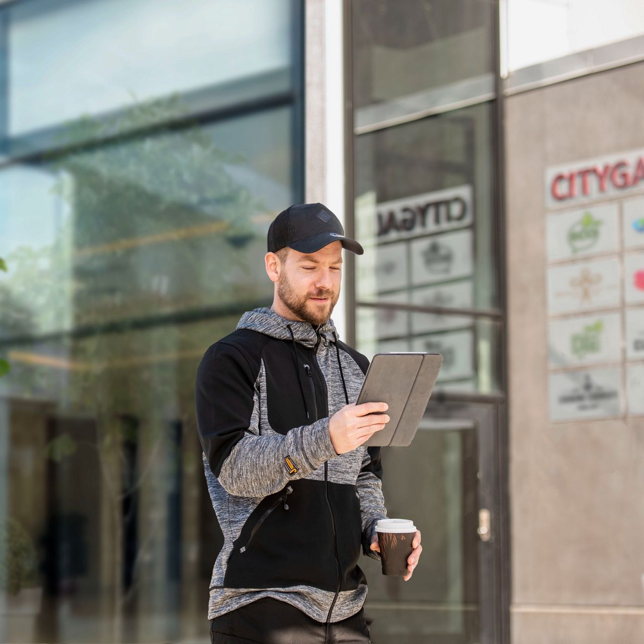 Mand med tablet og kaffe i hånden 