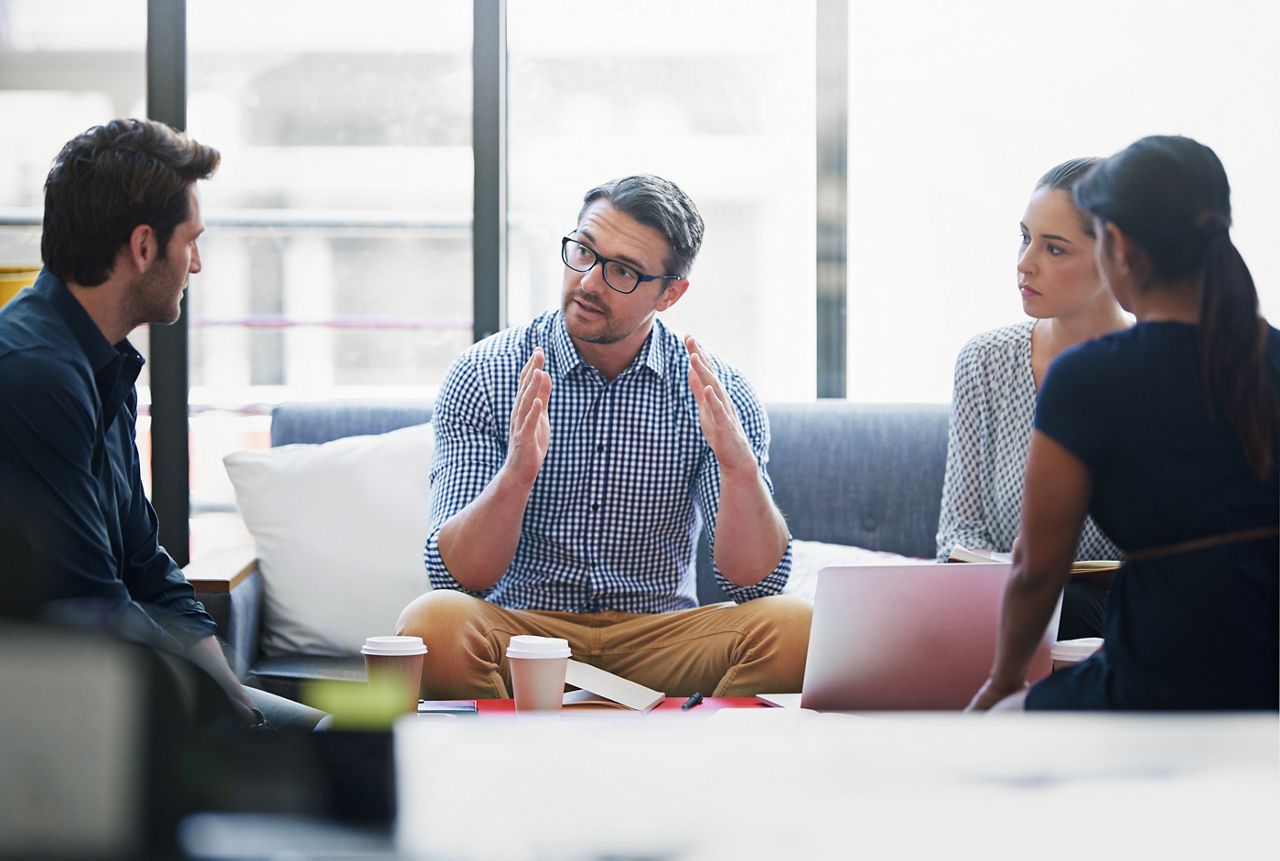 Meeting between 4 people sitting in a relaxed sofa area.