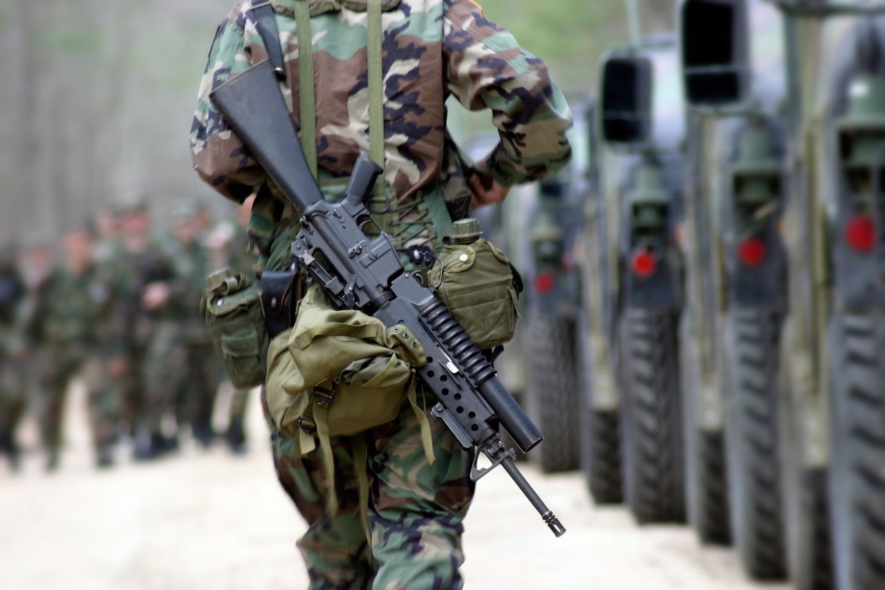 Militar caminhando com um rifle