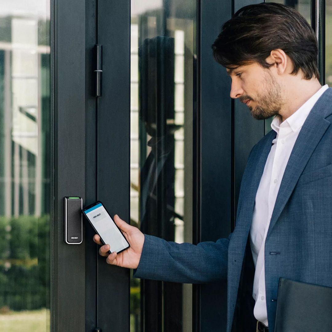 En man håller en mobiltelefon mot en kortläsare
