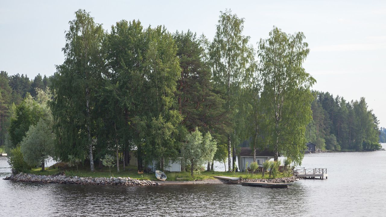 Kuva mökistä ja laiturista pienessä saaressa.