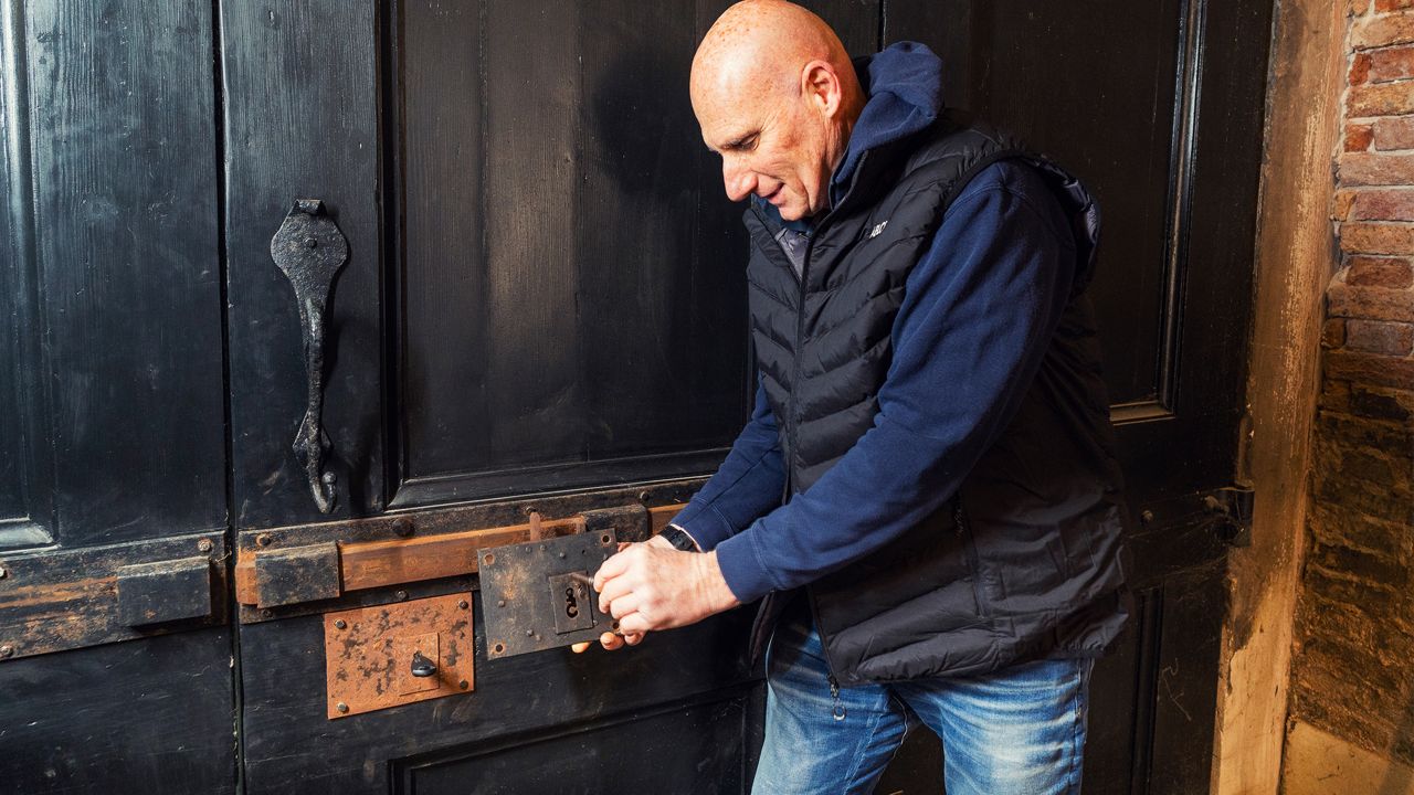 MUVE employee is comparing locks on a door