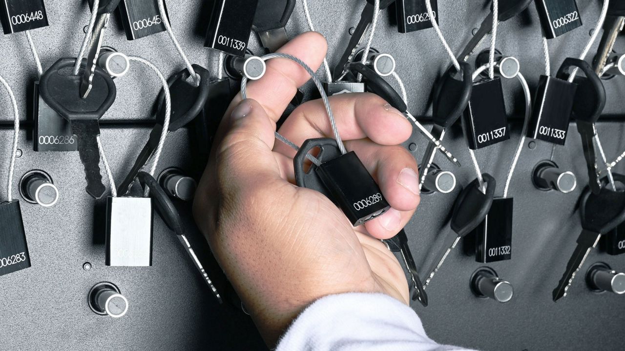Hombre retirando una llave de un armario de llaves Traka
