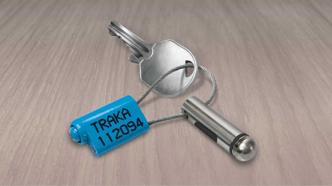 Intelligent, electronic fob on table secured to key with security seal
