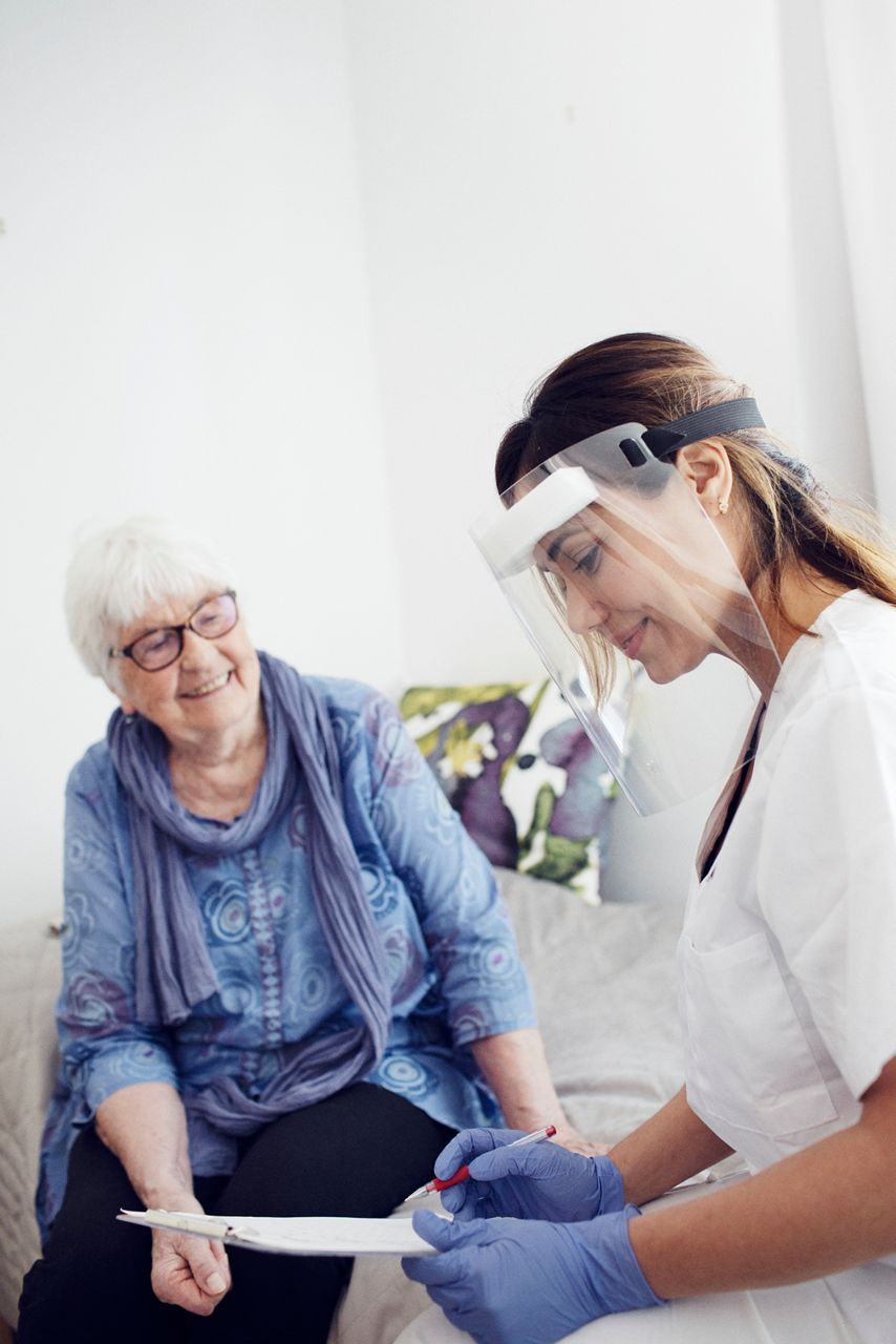 Elderly women helped by nurse.