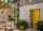 Patio with an open yellow door and Yale Outdoor alarm on the wall.