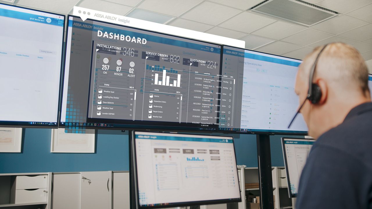 Muž se sluchátky sedící před monitory