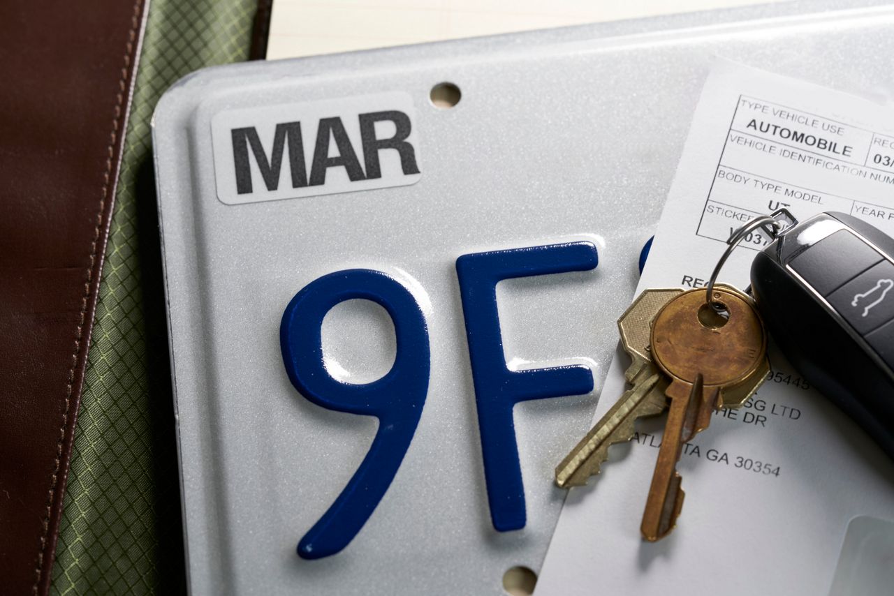 Dealer plate and vehicle keys on a desk