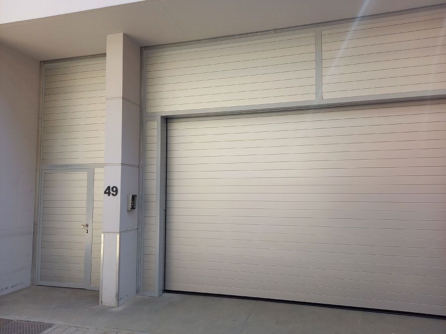Porte sectionnelle avec porte et portillon réalisés dans le même matériau pour un aspect harmonieux