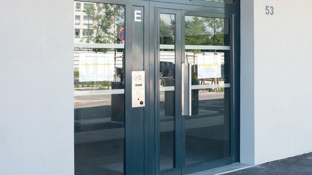 Porte de hall d'entrée fermée grise et vitrée