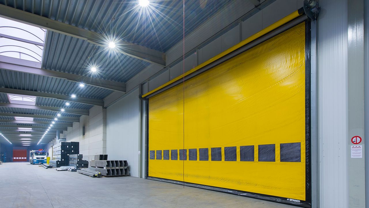 A wide yellow high-speed door in industrial environment.