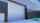 Gray industrial building with a closed roller shutter.