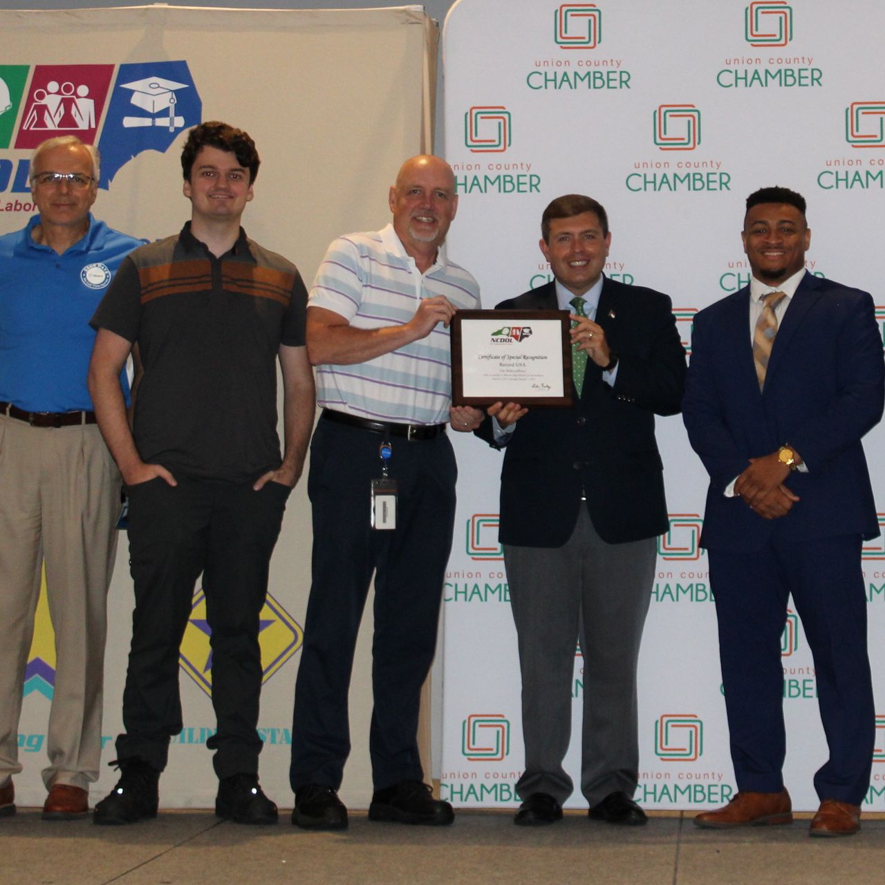 Members of the Record USA production team stand on stage to receive their award.