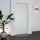 Porte blindée fichet blanche d'appartement dans un hall avec une plante verte